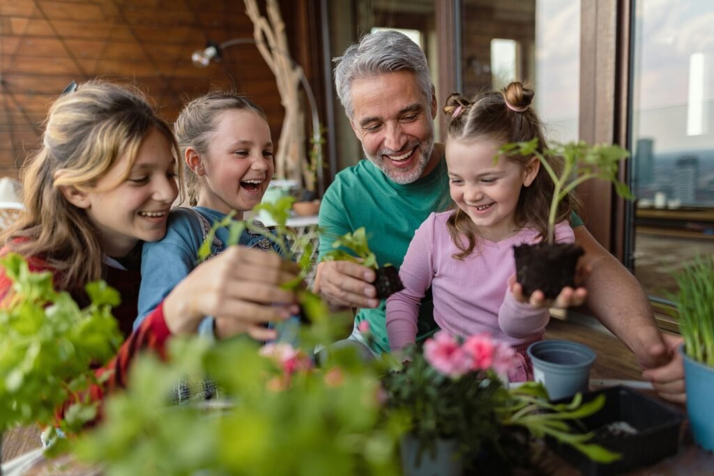 Família sorridente cultivando mudas em vasos, simbolizando conexão, bem-estar e harmonia através da jardinagem.