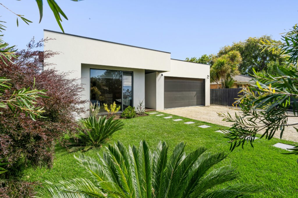 Casa moderna com jardim bem cuidado e gramado verde em destaque