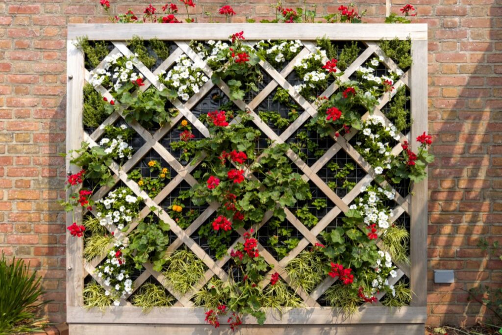 Jardim vertical com flores vermelhas e brancas em estrutura de madeira decorativa