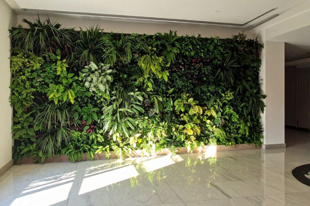 Jardim vertical com plantas verdes decorando parede interna.