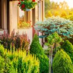 jardim residencial com arbustos, árvores decorativas e vasos suspensos com flores vermelhas, representando diferentes tipos de espaços verdes