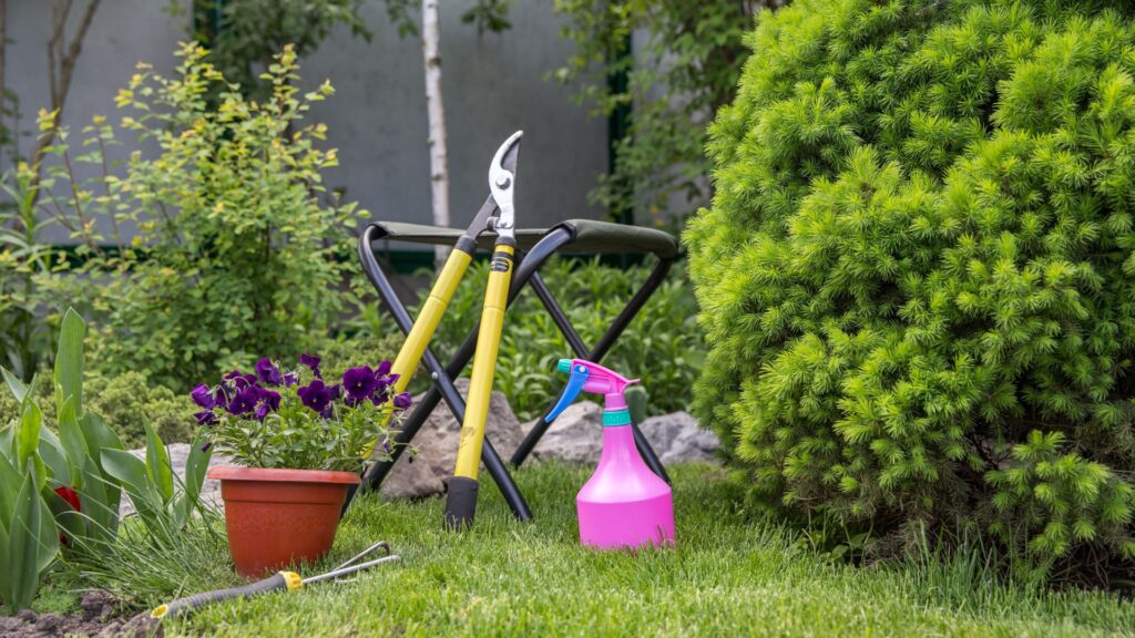 Conjunto de ferramentas de jardinagem com tesoura de poda, borrifador, vaso de flores e banco de apoio em um jardim verde, simbolizando o cuidado e o equilíbrio com a natureza.