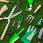 Kit de ferramentas de jardinagem para pequenos espaços e vasos, incluindo pás, tesouras de poda, borrifador e luvas sobre gramado artificial.
