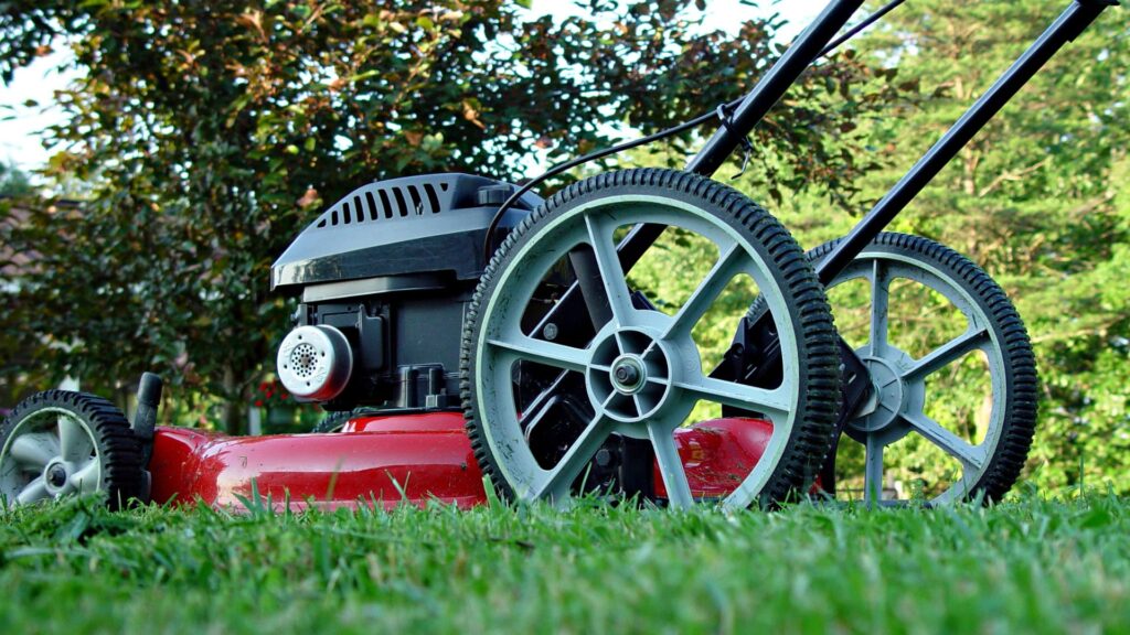 cortador de grama a gasolina com tração em destaque sobre gramado verde