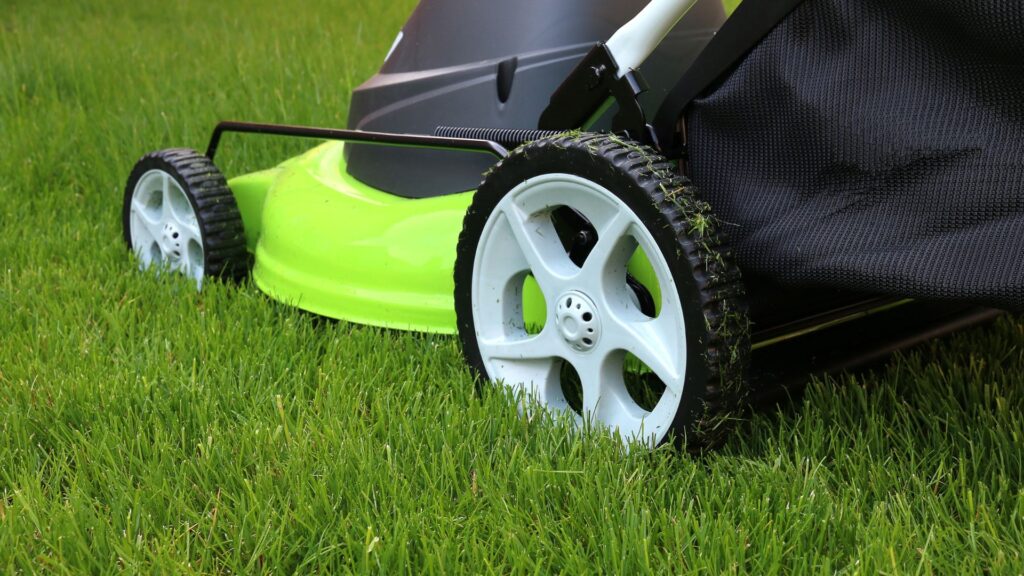 cortador de grama a gasolina com tração cortando grama alta em terreno inclinado
