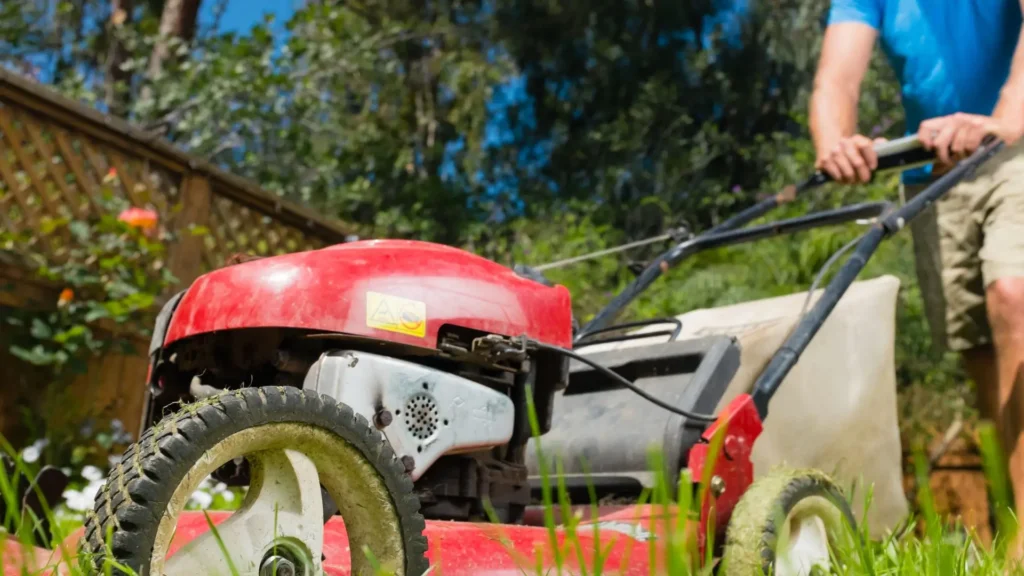Homem utilizando cortador de grama a gasolina com motor quatro tempos, representando durabilidade, força e desempenho em gramado residencial.