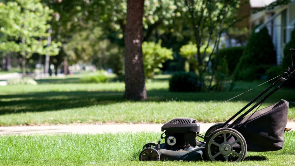 Cortador de grama automático sobre gramado residencial, representando equilíbrio entre conforto e sustentabilidade no cuidado do jardim.