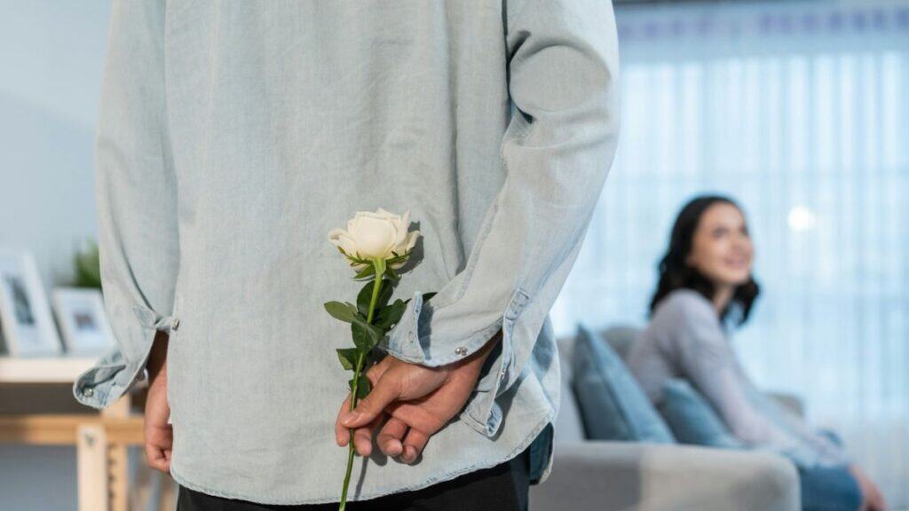 flores para o Dia da Mulher representadas por uma rosa branca entregue em gesto simples e respeitoso