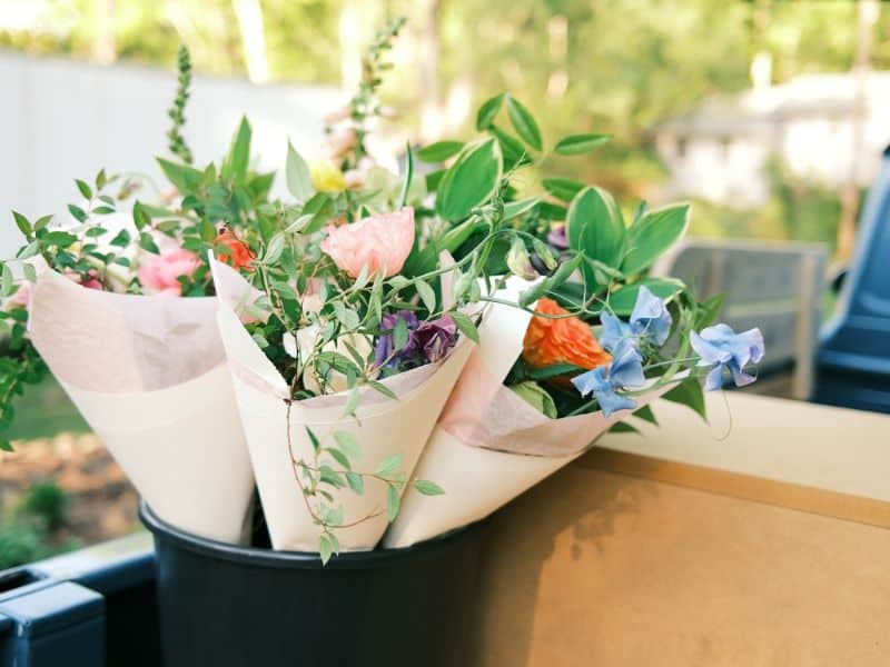 Buquês simples de flores variadas embalados de forma delicada, representando lembrancinhas do Dia da Mulher com significado simbólico