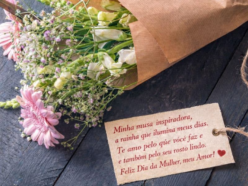 cartão com mensagem excessivamente romântica em buquê de flores representando exemplo do que evitar nas mensagens ao Dia Internacional da Mulher