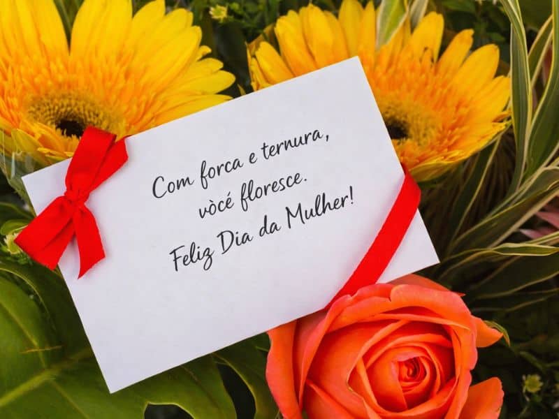 cartão com mensagem dia da mulher entre flores amarelas e rosa laranja representando gesto simples com significado