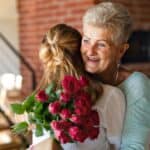 Mãe recebendo buquê de flores para Dia das Mães em momento de carinho