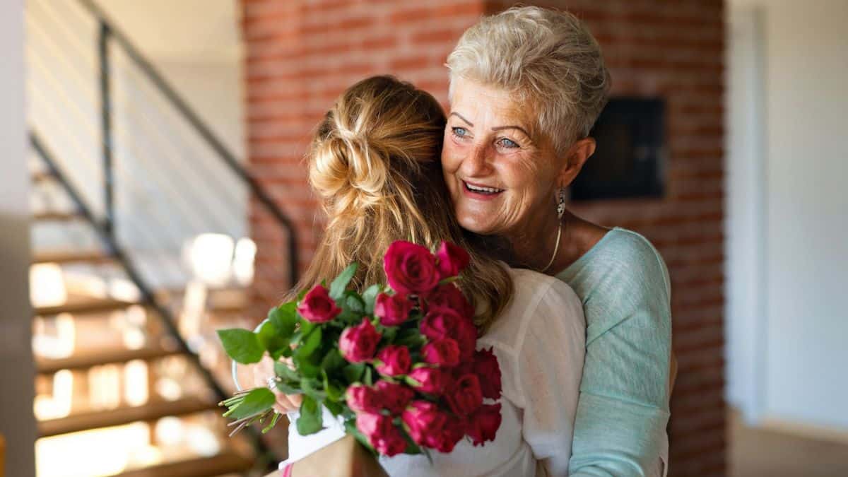 Mãe recebendo buquê de flores para Dia das Mães em momento de carinho