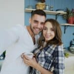 Casal feliz em cozinha moderna durante momento de rotina familiar em casa
