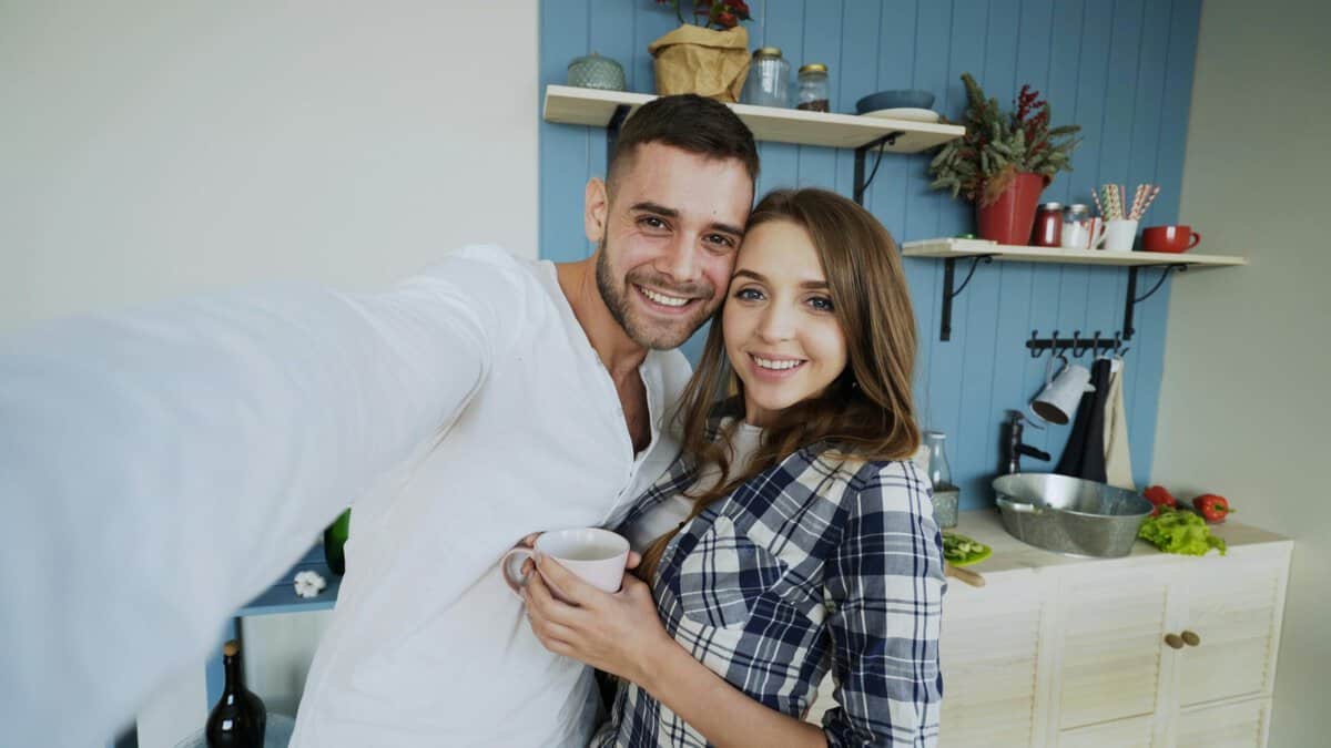 Casal feliz em cozinha moderna durante momento de rotina familiar em casa
