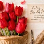 Mensagens para o Dia das Mães em cartão com tulipas vermelhas e presente artesanal sobre mesa clara