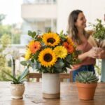 Pai recebendo uma planta em vaso como presente de uma filha adulta